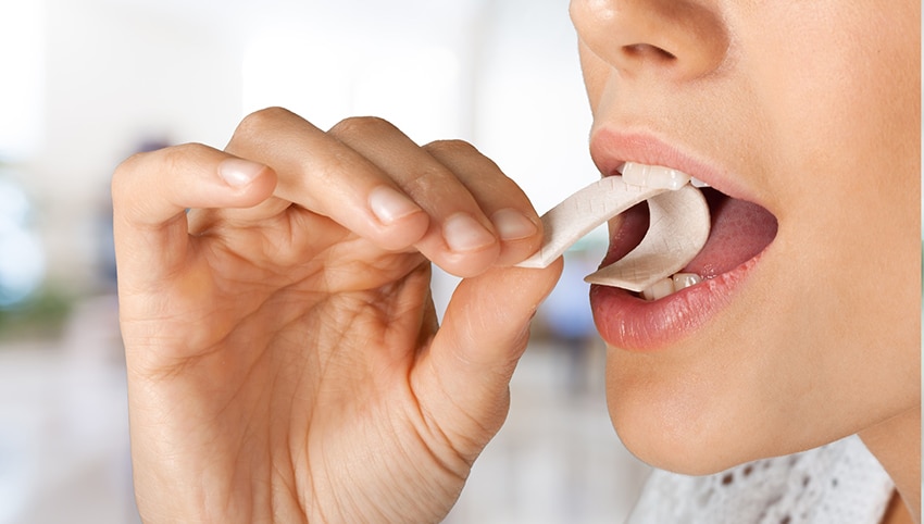 Woman starting to eat a piece of gum