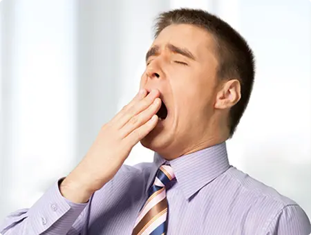 A man yawning while at work needs treatment for Sleep Apnea