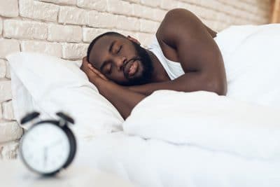 young Black American rests peacefully in bed