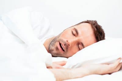 man sleeping soundly while laying in bed