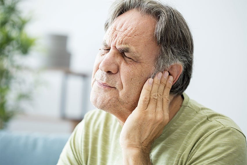 senior man suffering from ringing in his ears